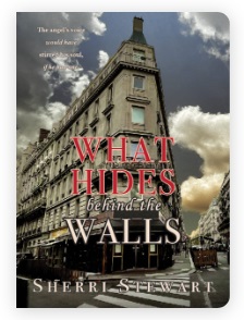 image of book cover What Hides Behind the Walls by Sherri Stewart. A street-view angle looking up at an historic triangle building with blue sky and clouds